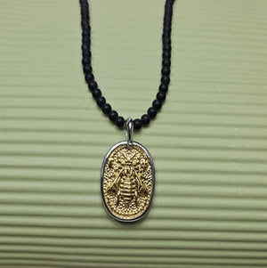 Black Onyx beaded necklace with silver and gold honey bee pendant, featuring elegant pendant detail and beaded chain.