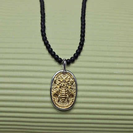 Black Onyx beaded necklace with silver and gold honey bee pendant, featuring elegant pendant detail and beaded chain.