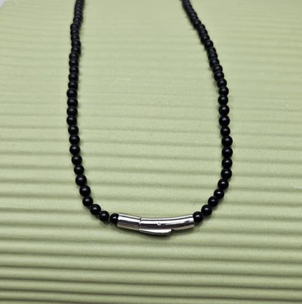 Black onyx beaded necklace with silver and gold honey bee pendant, featuring intricate detailing and a polished finish.