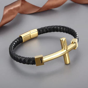 Gold flat braided leather bracelet with a large cross charm, stylish T.M.J leather bracelet accessory.