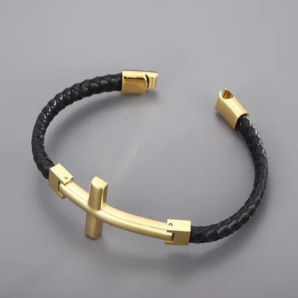 Gold flat braided leather bracelet with a large cross charm, stylish T.M.J leather bracelet for a bold accessory look.