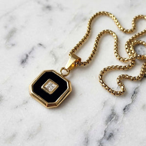 Aurex Onyx and Princess-Cut CZ pendant with PVD-plated stainless steel chain, featuring elegant gemstone accents and intricate design.