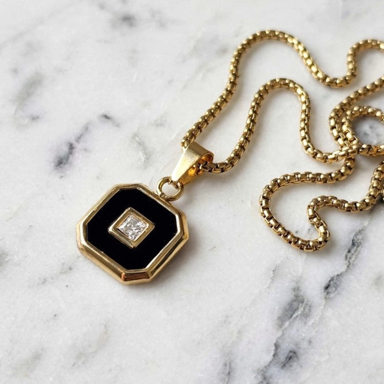 Aurex Onyx and Princess-Cut CZ pendant with PVD-plated stainless steel chain, featuring elegant gemstone accents and intricate design.