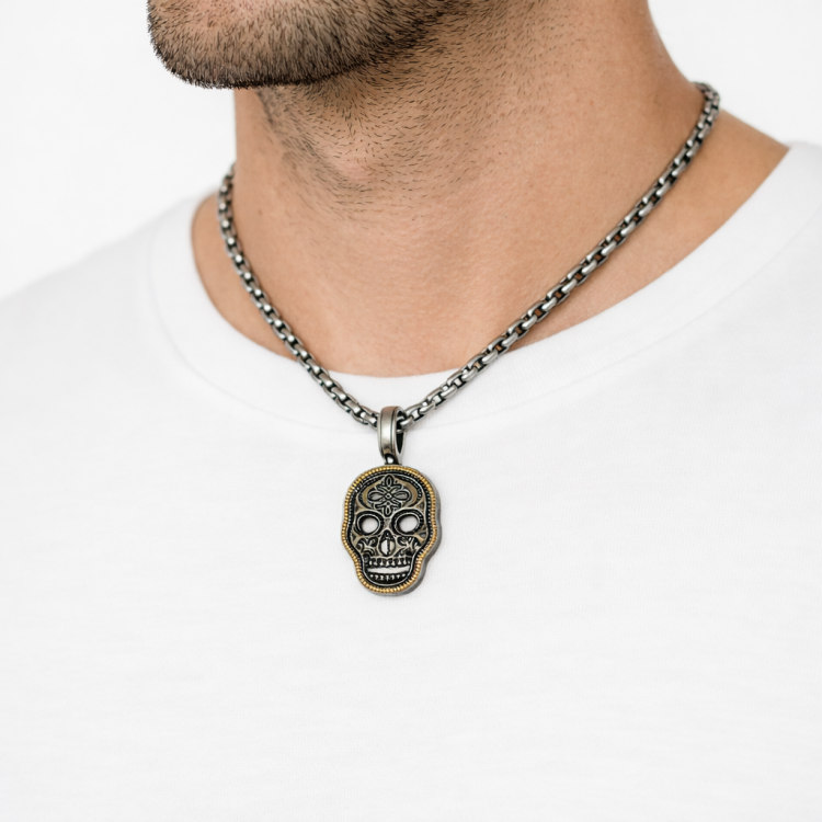 Gold and silver pave skull pendant on chain, T.M.J jewelry, detailed metallic skull design with sparkling stones.