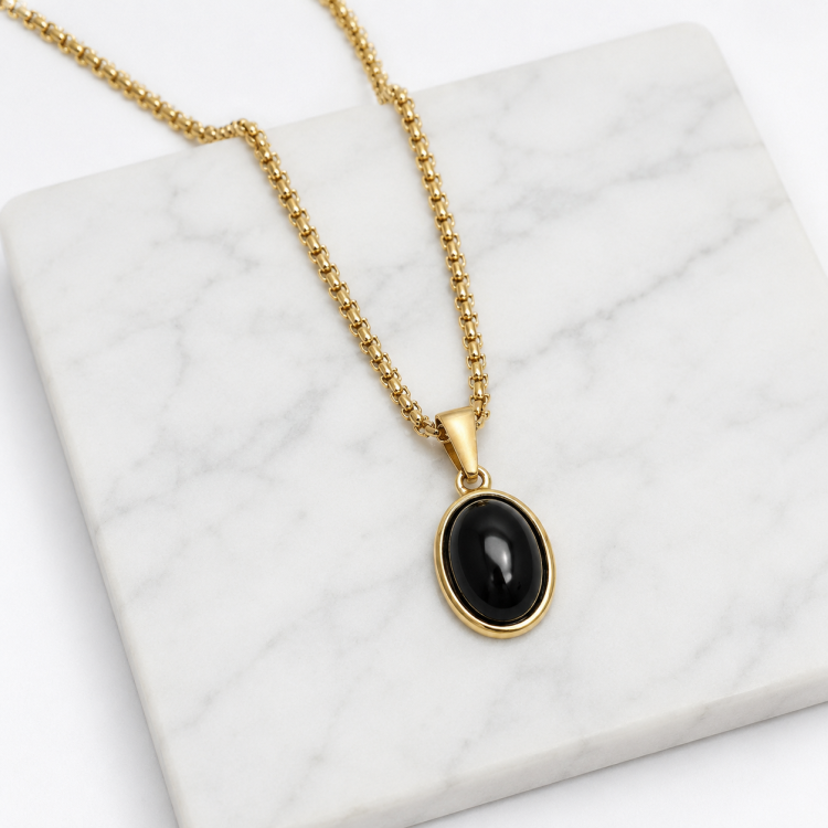 Gold-plated steel pendant with black agate cabochon, featuring T.M.J’s Halcyon pendant design.