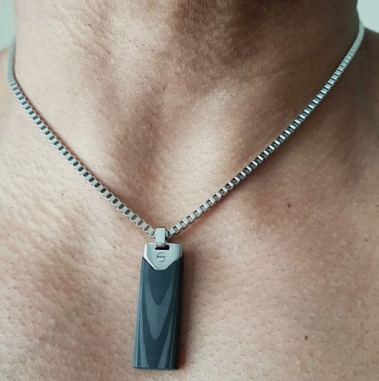 Men's stainless steel and carbon fiber dog tag pendant by T.M.J, featuring a sleek, modern design with textured surface details.