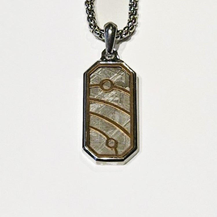 Muonionalusta meteorite pendant by T.M.J, stainless steel with gold-plated detail, showcasing a unique meteorite design.