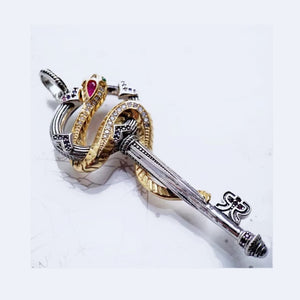 Silver and gold plated snake pendant with key and crystal accents, by T.M.J, featuring intricate detailing and sparkling embellishments.