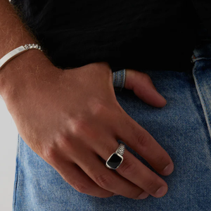 Vanguard men's sterling silver ring with a black onyx stone, crafted by T.M.J, showcasing a sleek and polished design.