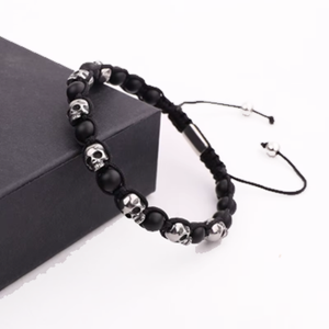 Adjustable stainless steel skull macrame bracelet with black agate beads, featuring a sleek T.M.J design.