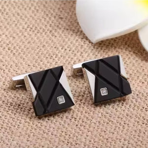 Elegant stainless steel and carbon fiber cufflinks with cubic zirconium accents, featuring a sleek, modern design.