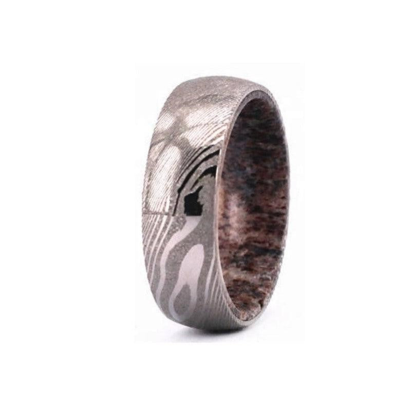 Titanium ring by T.M.J with Damascus steel and deer antler insert, comfort fit design, polished finish, top view.