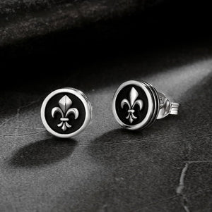 Men's black onyx stud earrings with fleur-de-lis center by TMJ, showcasing sleek 9mm round design and intricate detail.
