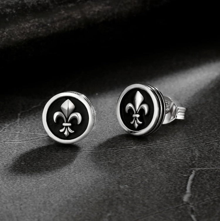 Men's black onyx stud earrings with fleur-de-lis center by TMJ, showcasing sleek 9mm round design and intricate detail.
