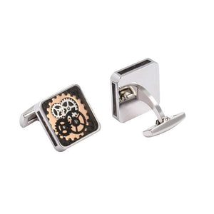T.M.J mechanical cufflinks with stainless steel finish and carbon fiber background, featuring a detailed watch design.